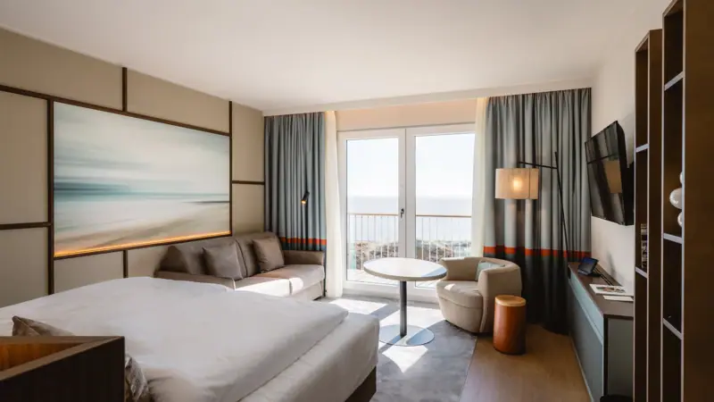 Zimmer mit Bett und Couch im modernen Design.