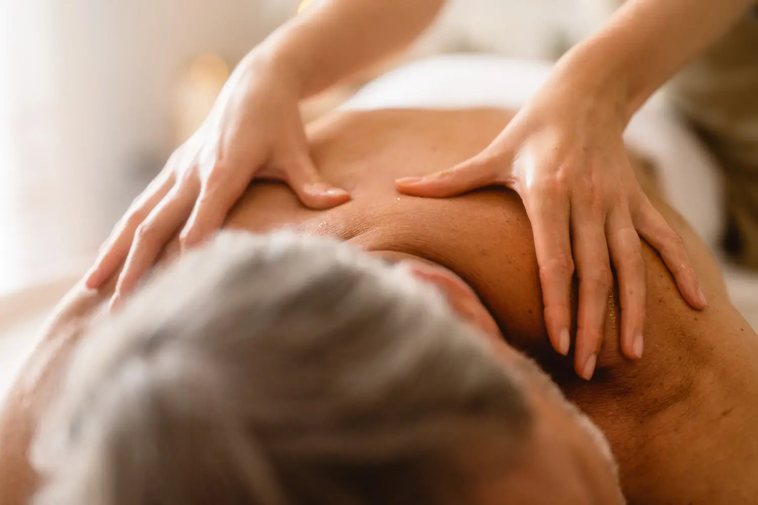 Gothische Massage Eine Person massiert den Rücken eines Mannes.