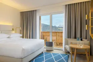 Schlafbereich Ein Hotelzimmer mit einem Bett, einem Teppich und einem Stuhl.