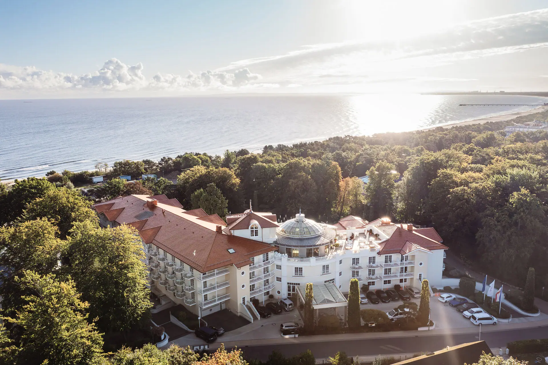 A-ROSA Heringsdorf Großes Gebäude mit Bäumen und einem Gewässer im Vordergrund.