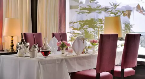 Ein Tisch mit einer weißen Tischdecke steht in einem Restaurant ist.