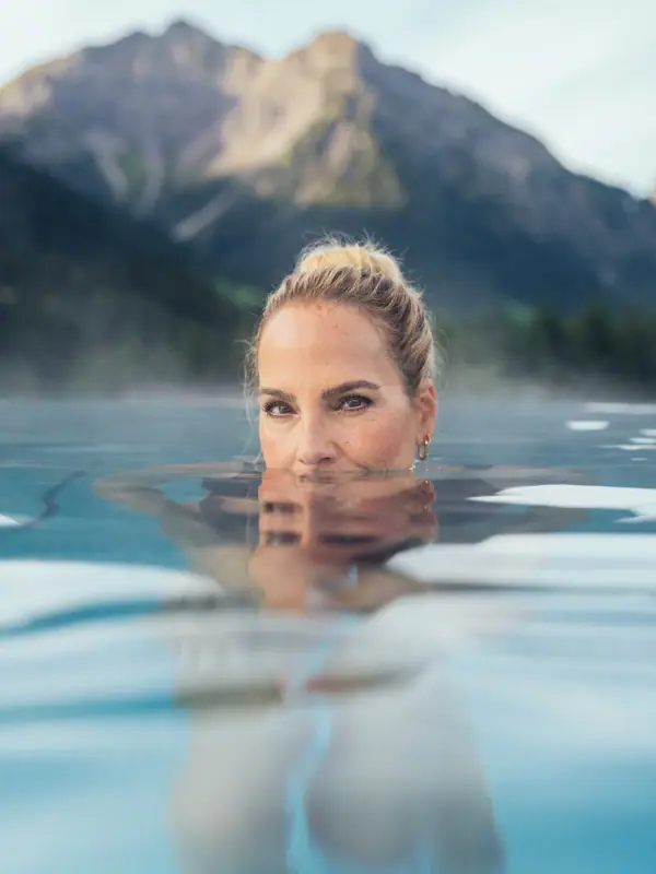 Eine Frau im Außenpool vom A-ROSA Ifen Hotel Kleinwalsertal
