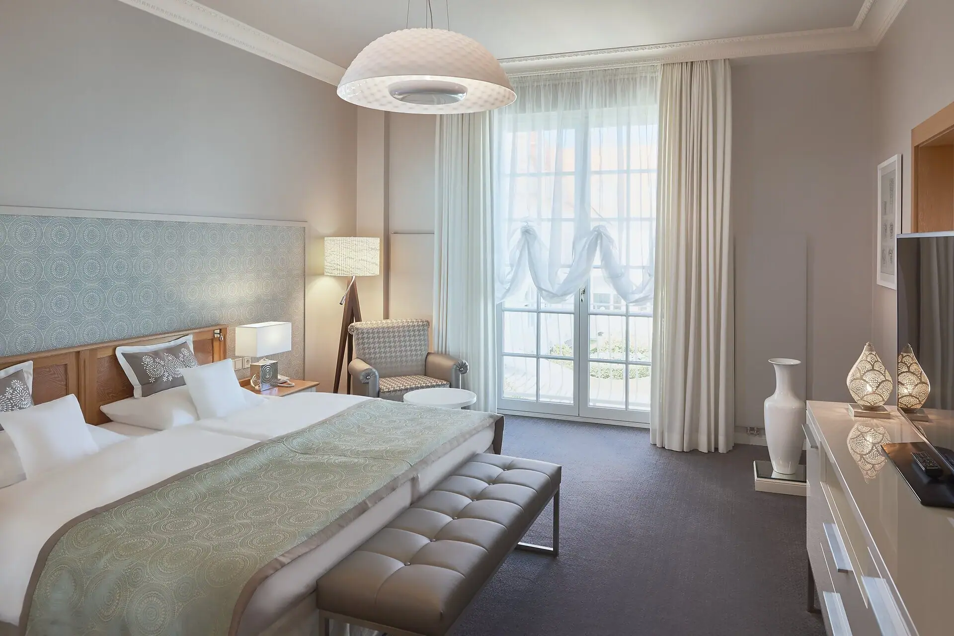 Ein Hotelzimmer mit einem Bett und einer Bank.