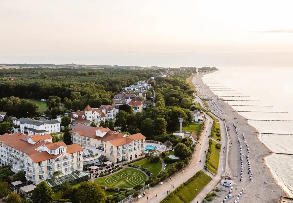 Strand mit Gebäuden und Bäumen aus der Vogelperspektive.