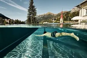 Ein Mann schwimmt in einem Außenpool.