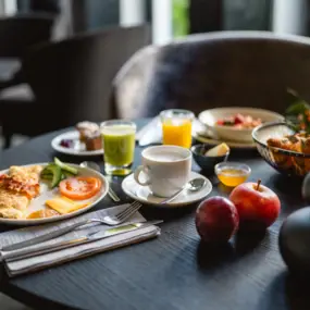 A champagne glass, orange juice, waffles and other dishes are elegantly arranged on a table. 