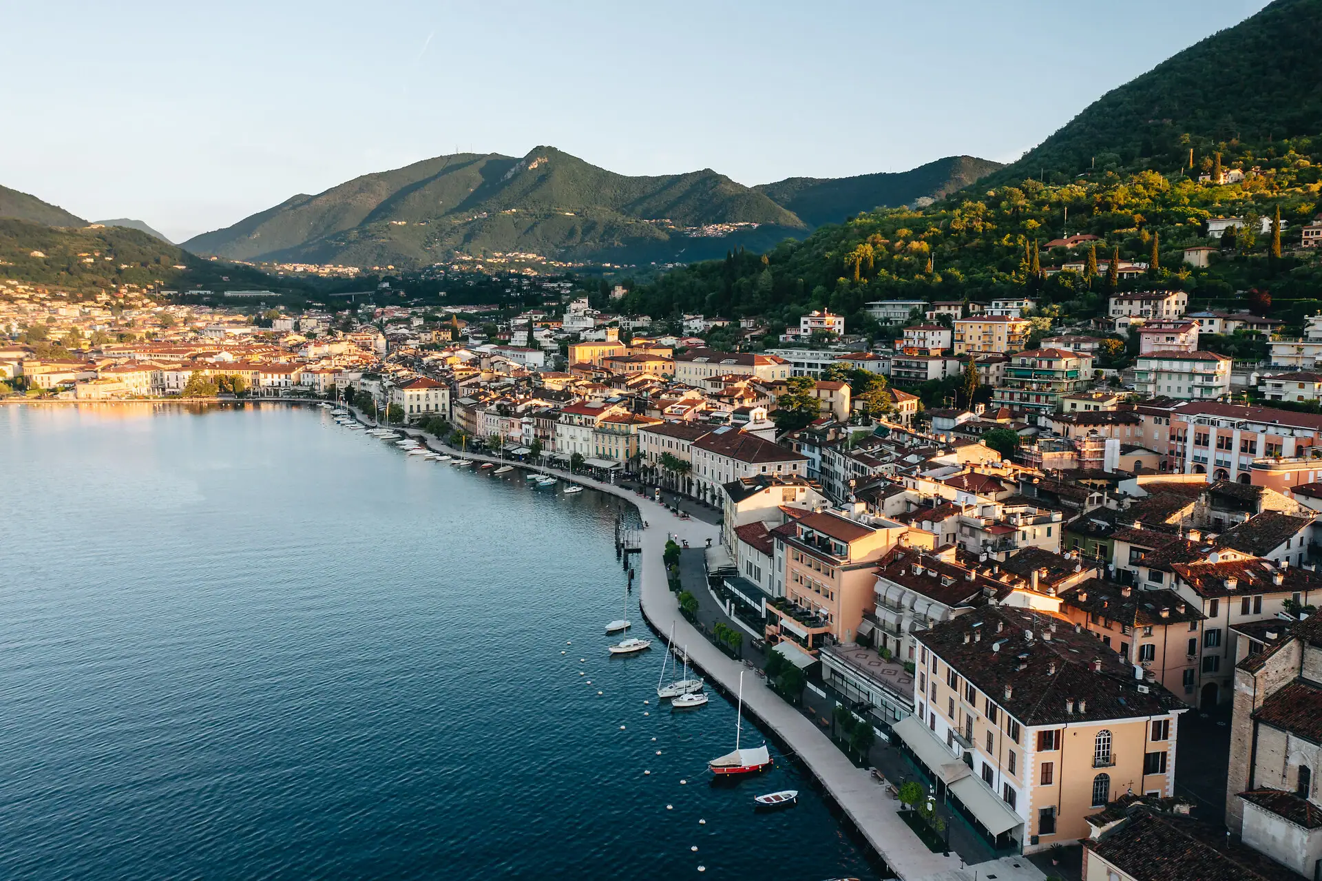 Stadt am Wasser mit Bergen im Hintergrund.
