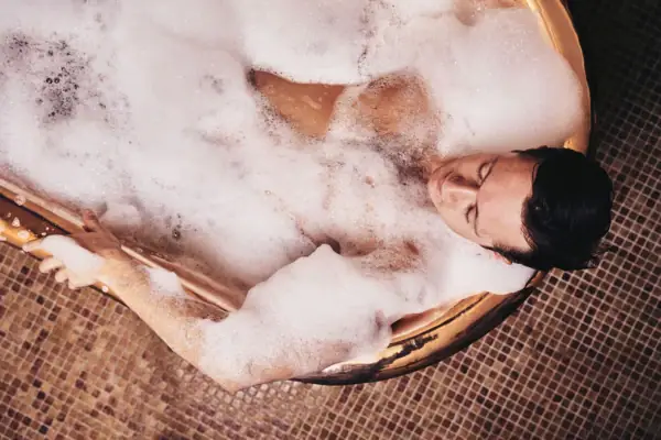 Private Wellnessmomente in der goldenen Kaiserwanne im A-ROSA Ostseehotel Kühlungsborn Frau entspannt in der goldenen Kaiserwanne mit Schaum und Wellness-Details im A-ROSA Ostseehotel Kühlungsborn