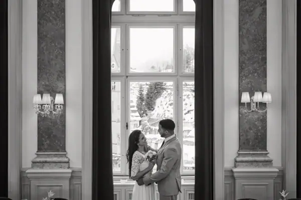 Ein Mann und eine Frau stehen in einem Raum mit Fenster.