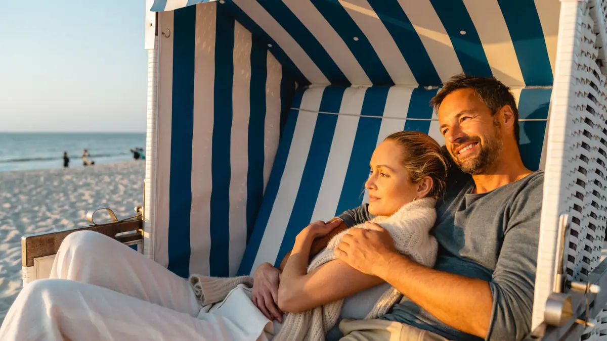Ein Mann und eine Frau sitzen in einem Strandkorb.