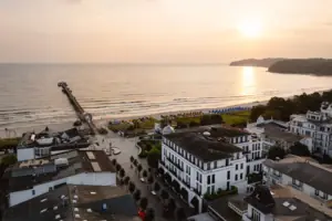 Strand mit Gebäuden und einem Pier im Hintergrund.