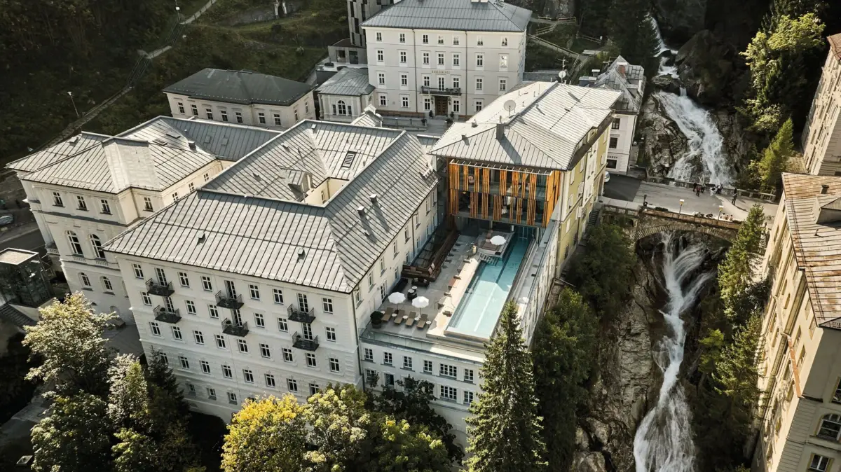 Ein renoviertes Hotel neben einem Wasserfall mit Außenpool und historischem Charme.
