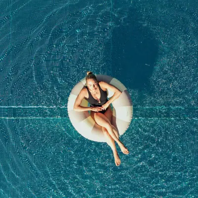 Poolparty Frau sitzt auf einem Schwimmreifen im Pool