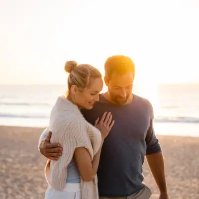 Ein Mann und eine Frau stehen am Strand und küssen sich.