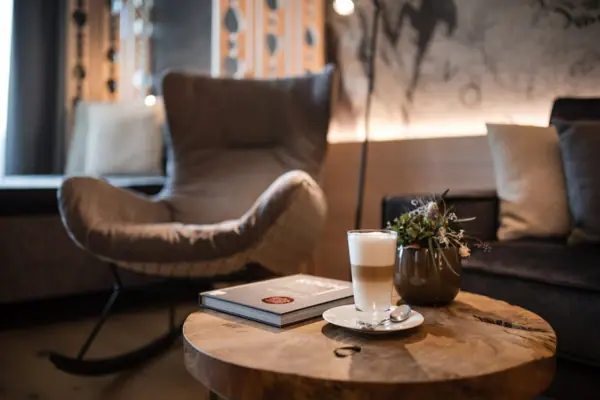 Sitzbereich Ein Tisch mit einem Buch und einem Glas Flüssigkeit darauf.