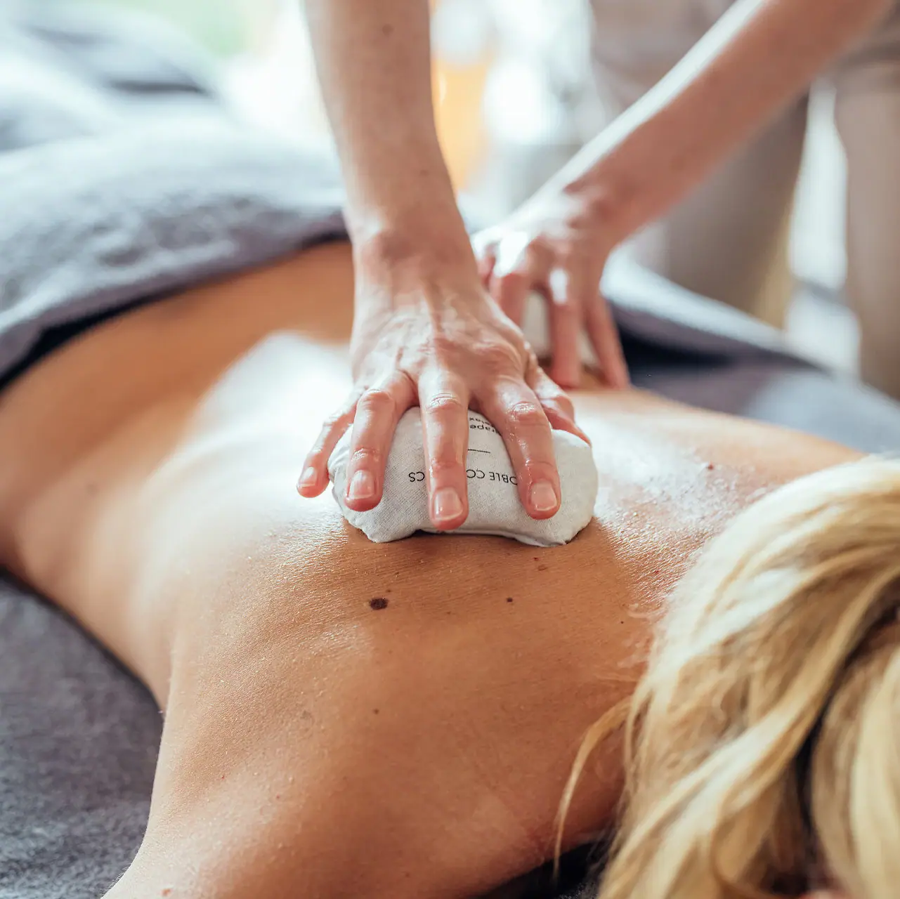 Eine Person gibt einer Frau eine Rückenmassage.