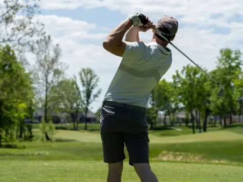 Ein Mann schwingt einen Golfschläger auf einem Golfplatz.