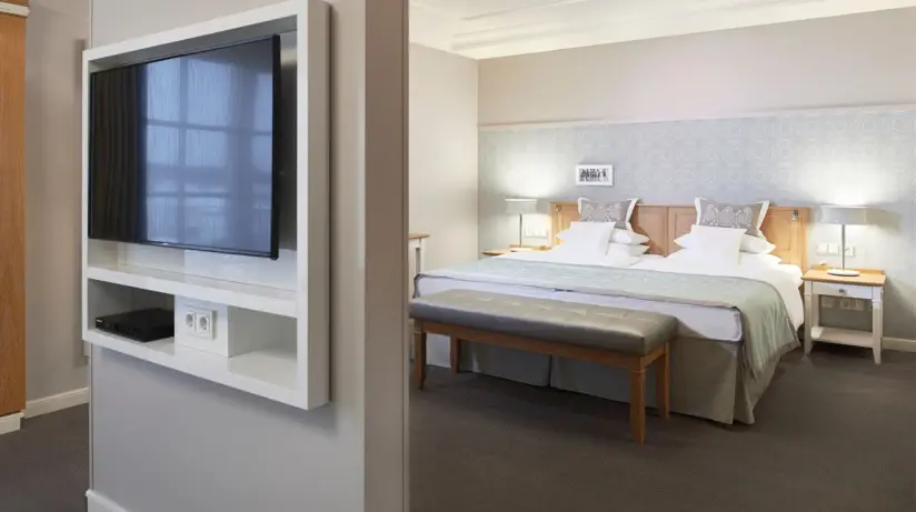 Ein Hotelzimmer mit einem Bett und einem Fernseher.
