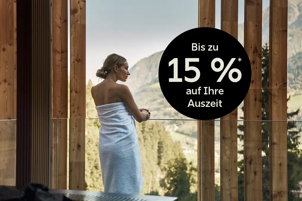 Eine Frau in ein Handtuch gewickelt schaut aus einem Fenster.