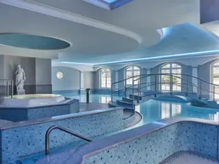 An indoor pool decorated in light blue tones.