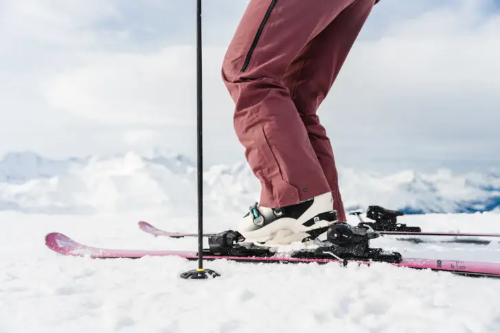 Beine und Füße eines Skifahrers auf verschneiter Piste