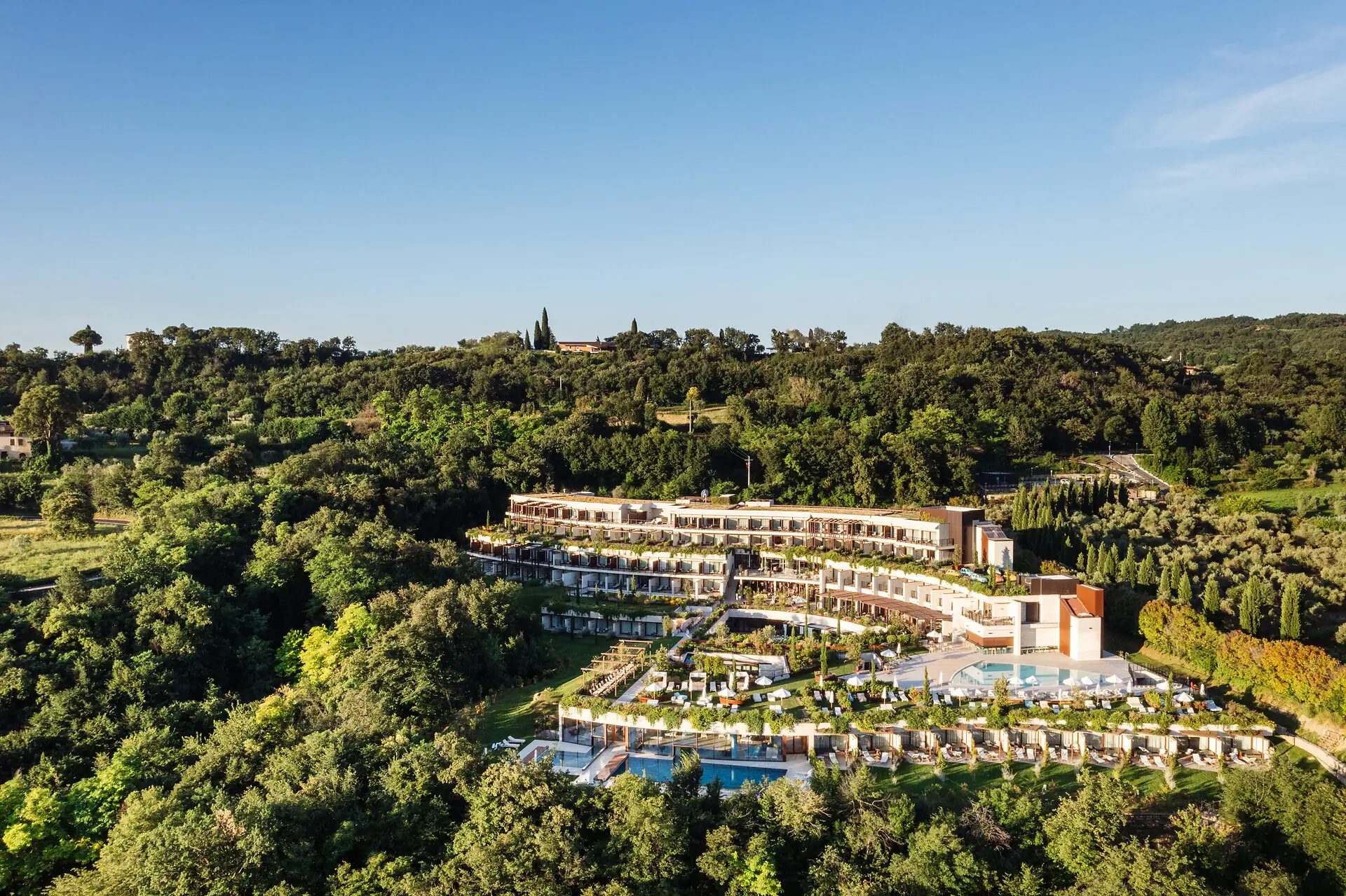 Ein Gebäude mit einem Pool, umgeben von Bäumen.