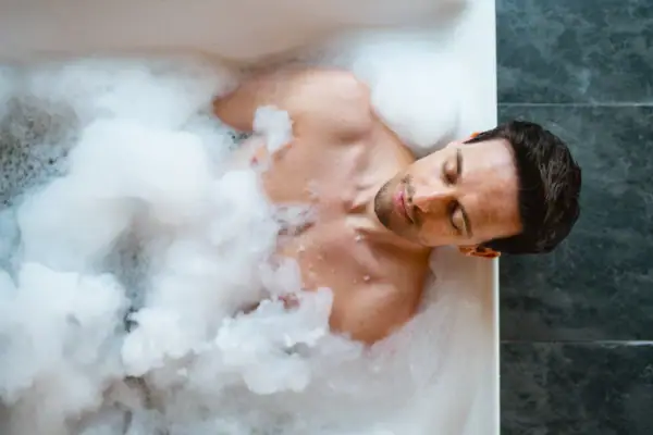 Mann in der Badewanne Ein Mann liegt in einer Badewanne mit Schaum.