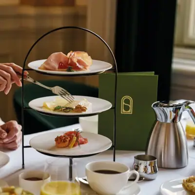 Eine Etagere mit Lebensmitteln, Teekanne und Menükarte