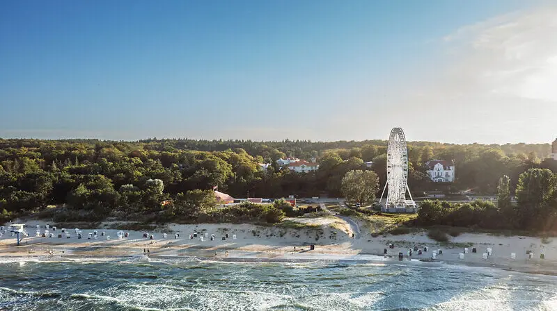 Strand mit Riesenrad und Bäumen im Hintergrund