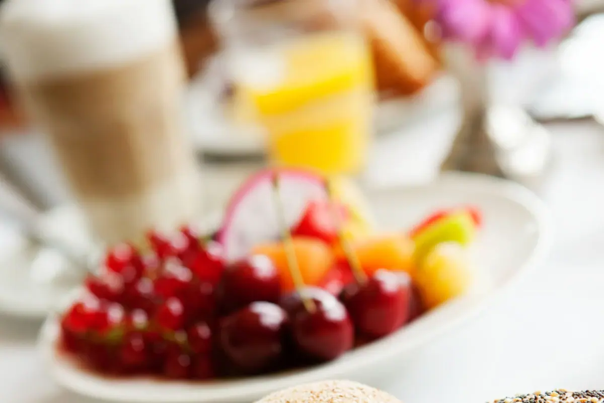 Frühstücksmomente Ein Teller mit Essen und Obst auf einem Tisch.