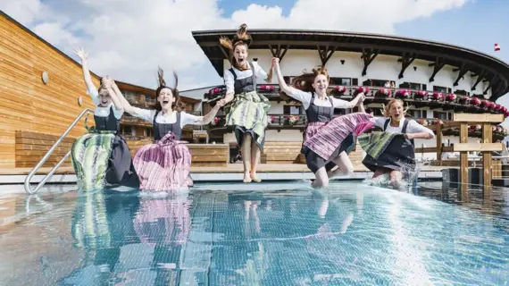 Gruppe von Frauen springt in einen Pool