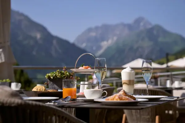 Frühstück Ein Tisch mit Speisen und Getränken vor der Kulisse von Hallstatt.