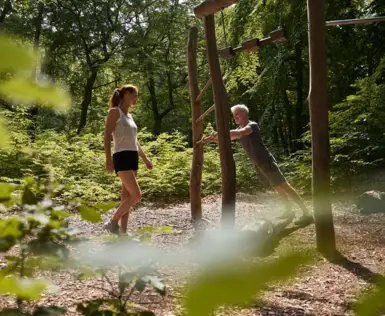 Man and woman exercising together in a forest