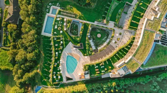 Aerial view of a hotel with pool and trees.