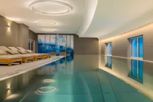 SPA-ROSA Tegernsee Der Innenpool im A-ROSA Hotel Tegernsee mit Liegestühlen am Rand.