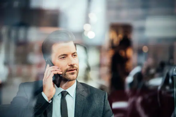 Telefonat Ein Mann im Anzug telefoniert mit einem Handy.