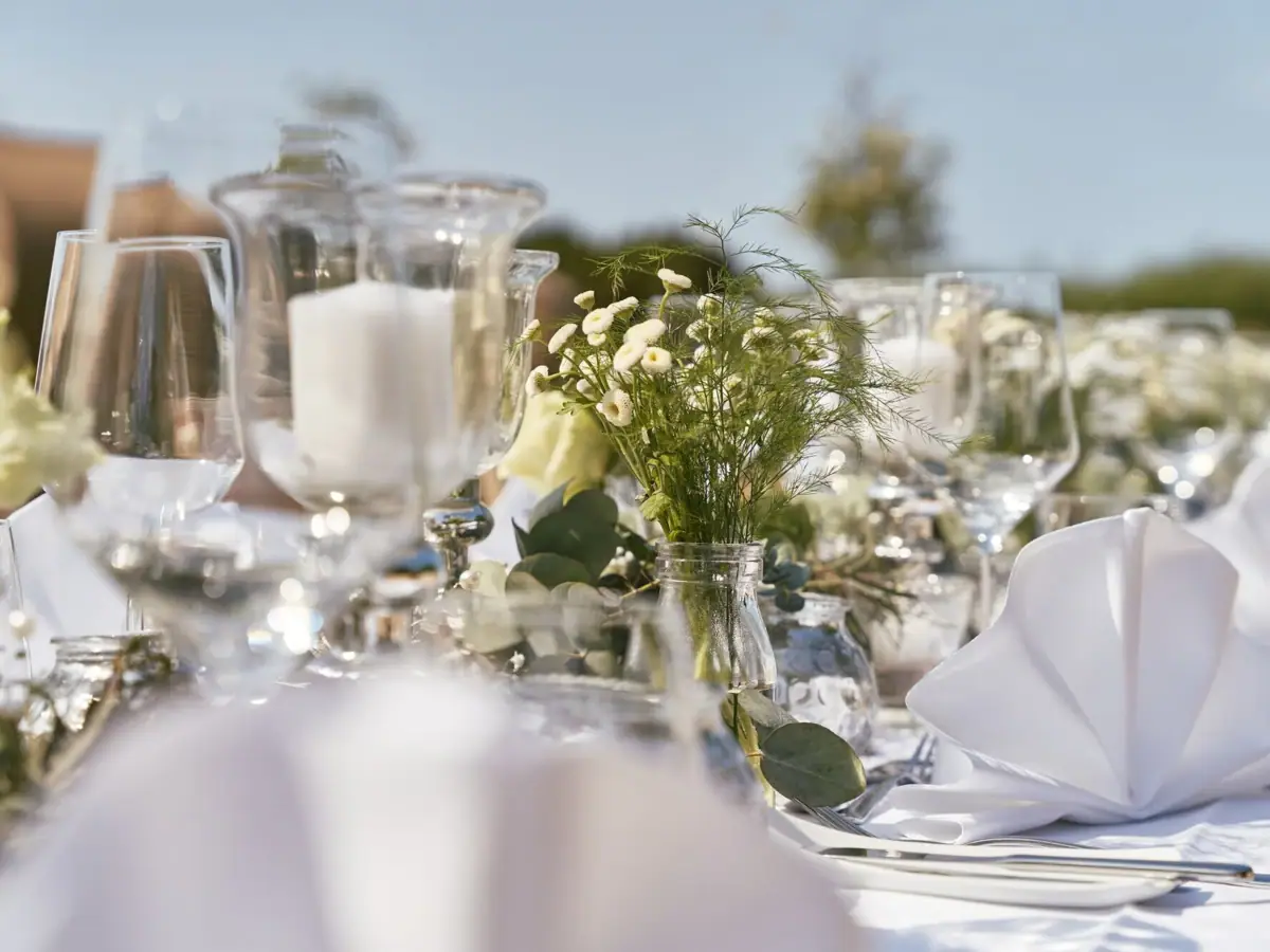 Ein Tisch mit Blumenarrangement und Kerzen.