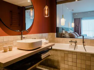 Modern bathroom featuring a sink, bathtub, and tiled walls.