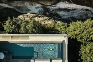 Eine Person schwimmt in einem Außenpool.