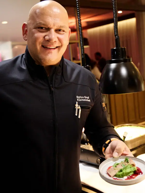 Ein Mann hält einen Teller mit Essen.