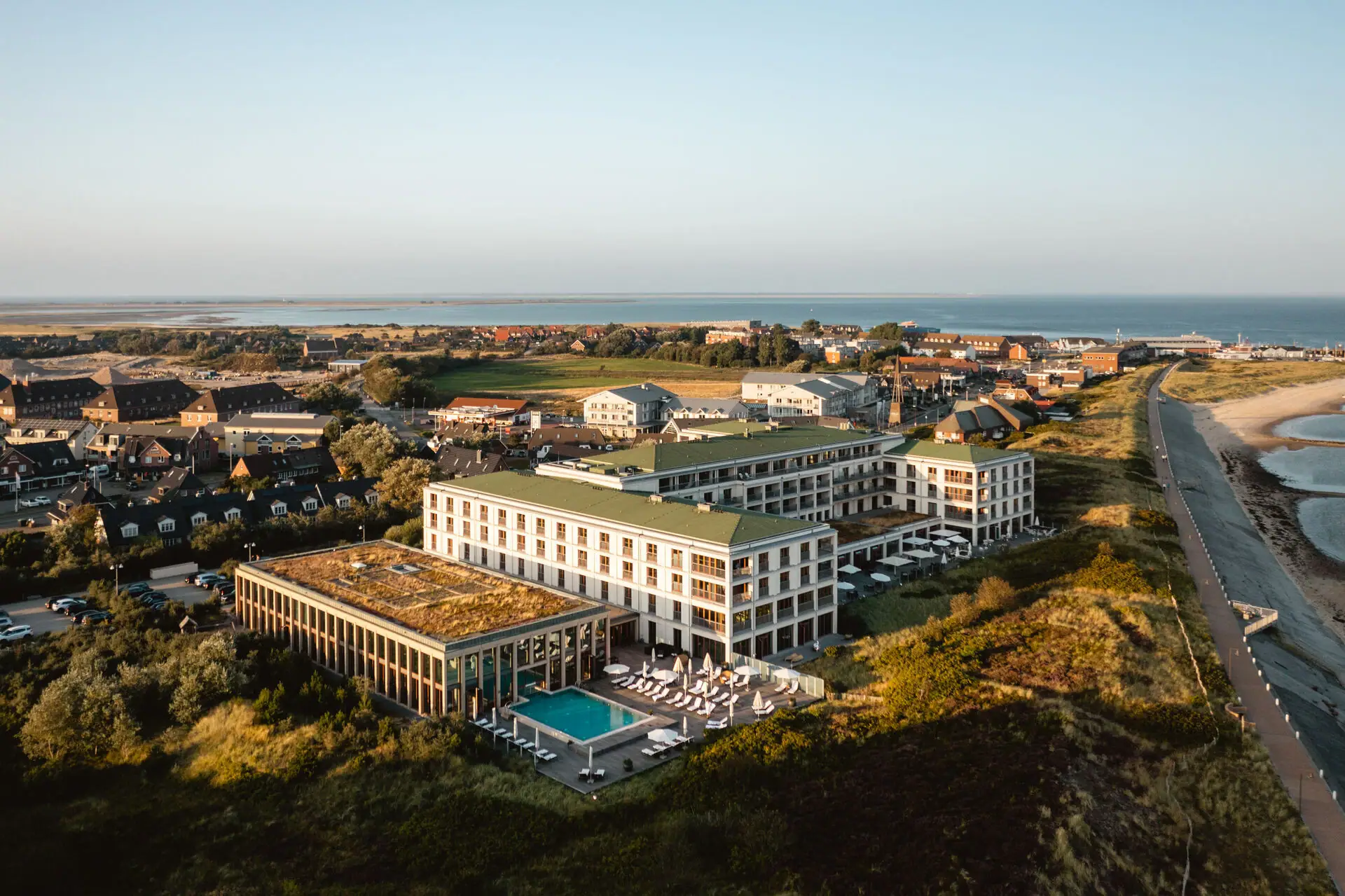 Das A-ROSA Sylt mit Pool direkt an den Dünen gelegen mit dem Strand und der Nordsee daneben.