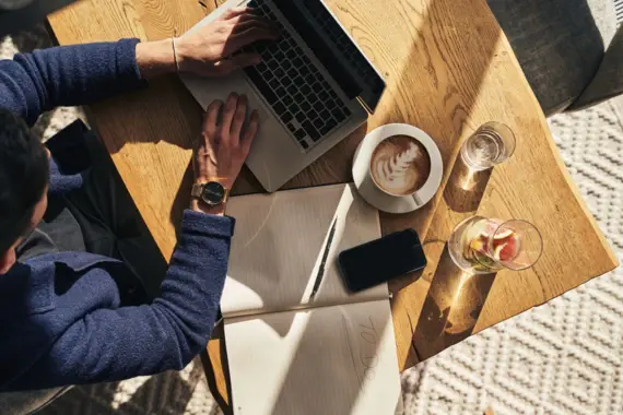 Person benutzt einen Laptop auf einem Tisch.