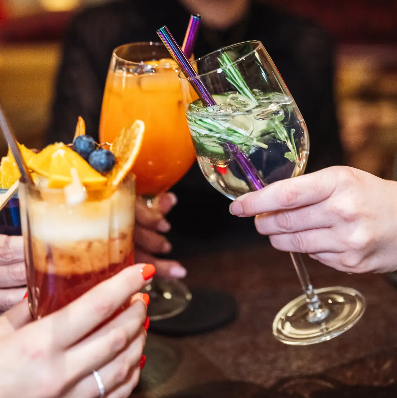 Drinks Eine Gruppe von Händen hält Gläser mit Cocktails.