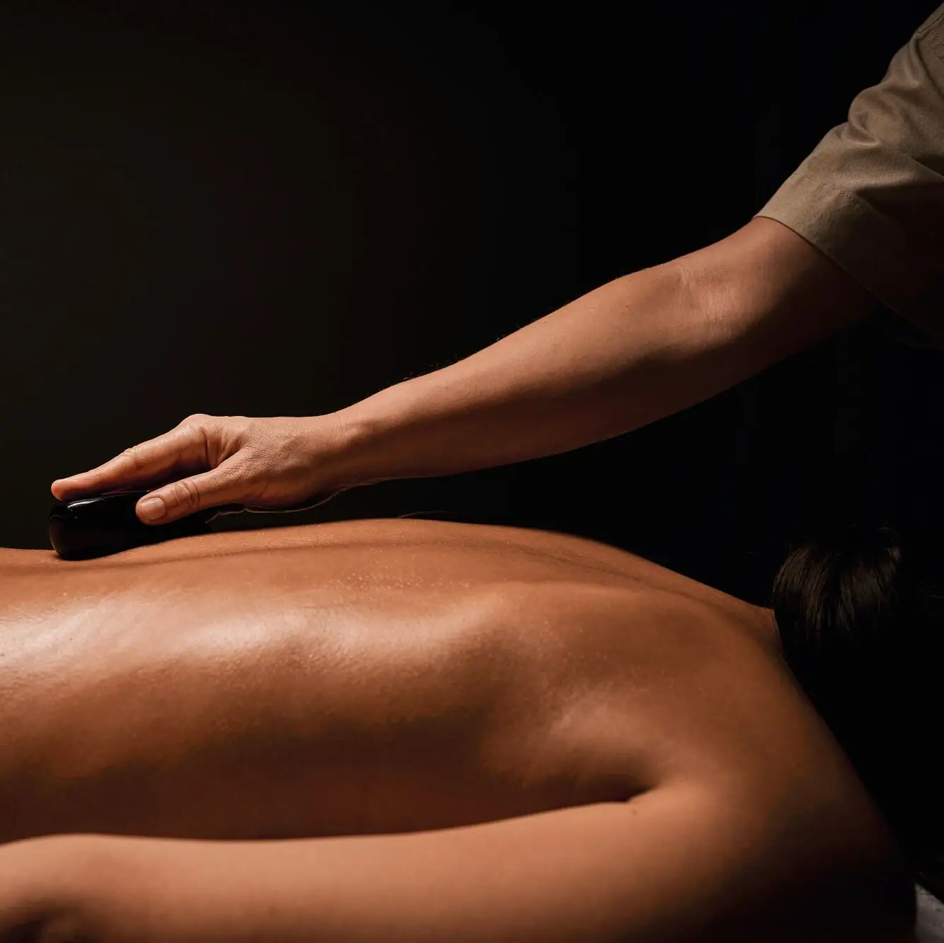 Nahaufnahme eines Rückens welcher mit Hot Stones behandelt wird