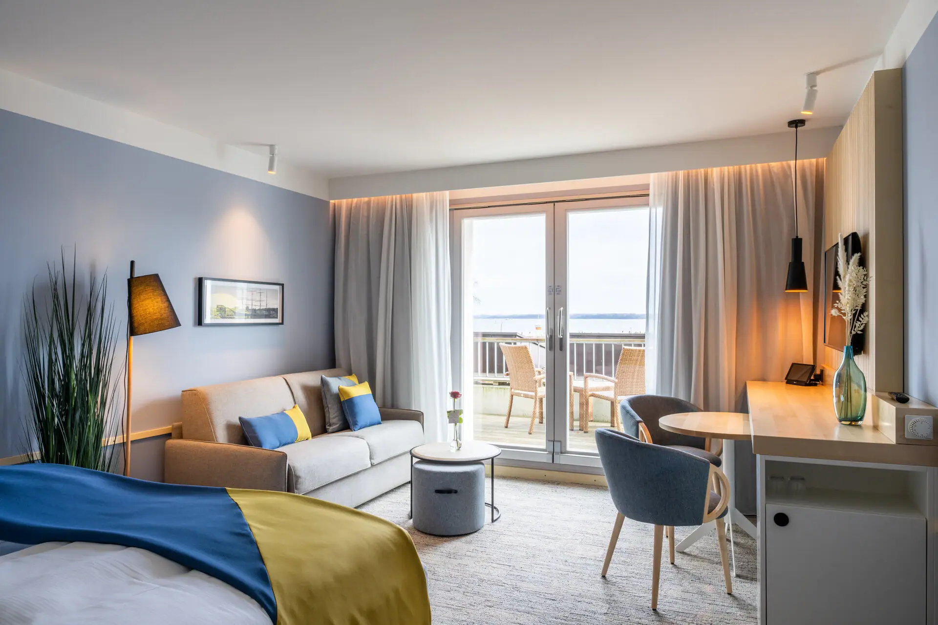 Zimmer Travemünde Ein modernes Hotelzimmer mit einem Bett und einem Sofa.