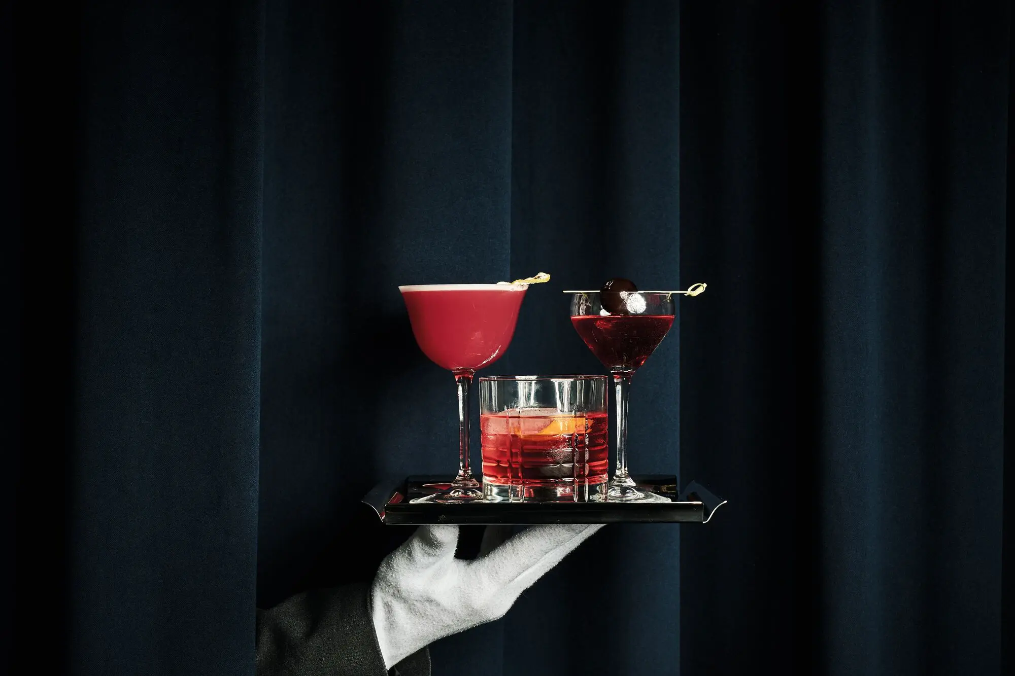 Ob neue Kreationen oder Klassiker, an unserer Bar bleiben keine Wünsche offen Ein Tablett mit verschiedenen Cocktails wird serviert.