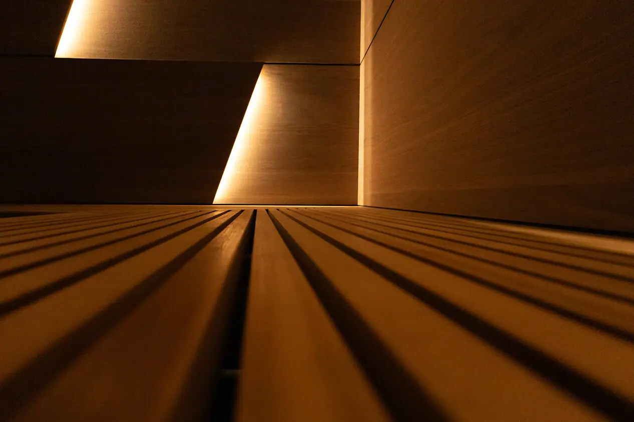 Holzwand mit Beleuchtung und symmetrischen Linien.