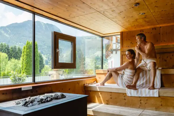 Ein Mann und eine Frau sitzen auf einer Bank in einer Sauna.