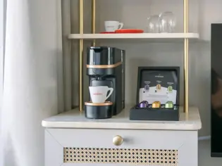 Coffee machine and coffee pod on a kitchen shelf.