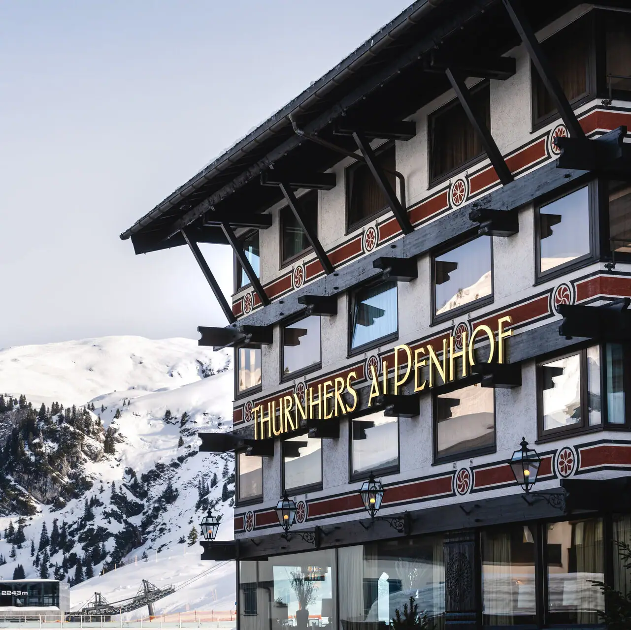 A-ROSA Hotel Thurnher's Alpenhof Gebäude mit einem Schild an der Seite im Freien bei winterlichen Bedingungen.